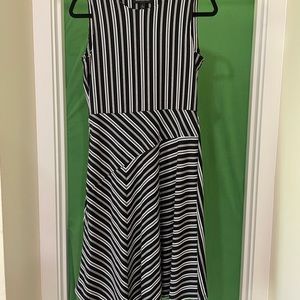 Black and white stripes, sleeveless with asymmetrical bottom. Poly/spandex blend